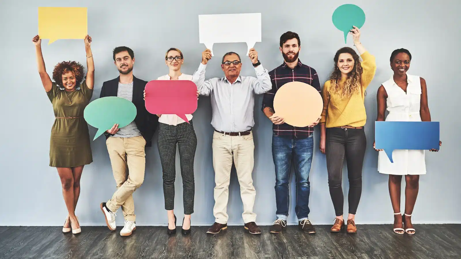 A group of coworkers holding different cutouts of chat bubbles